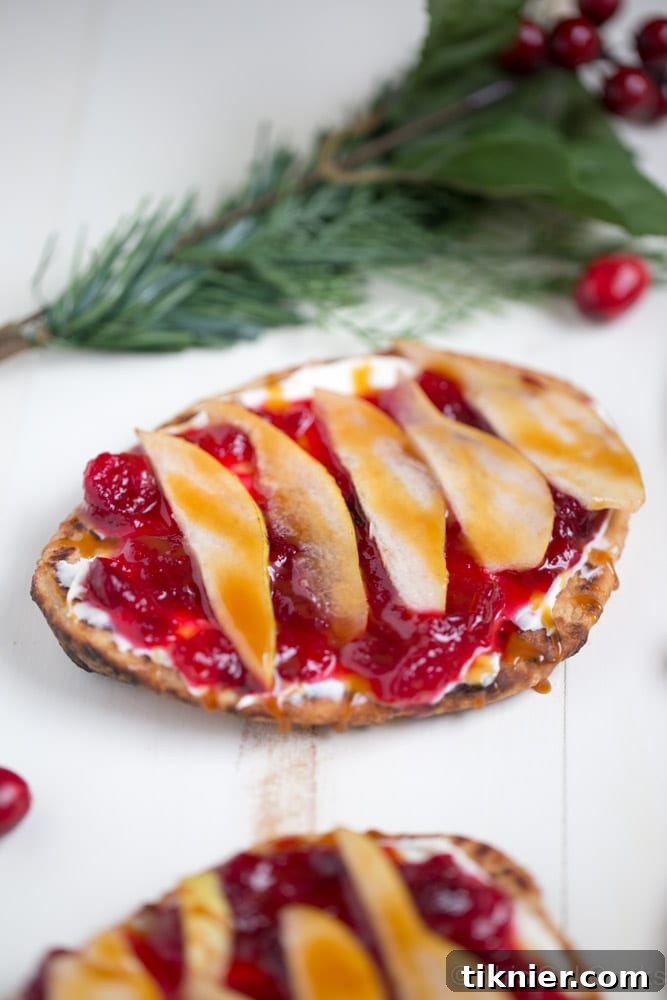 Delicious Cranberry Pear Flatbread, adorned with fresh cranberries and pear slices, suitable as an appetizer or light meal.