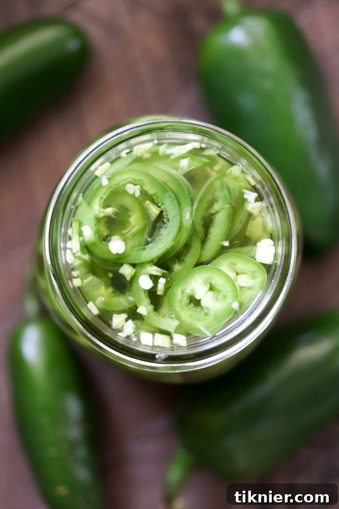 Instant Tangy Jalapeno Rounds 3 A vibrant close-up shot of freshly sliced green jalapenos, highlighting their crisp texture and the promise of spicy, tangy flavor about to be infused.