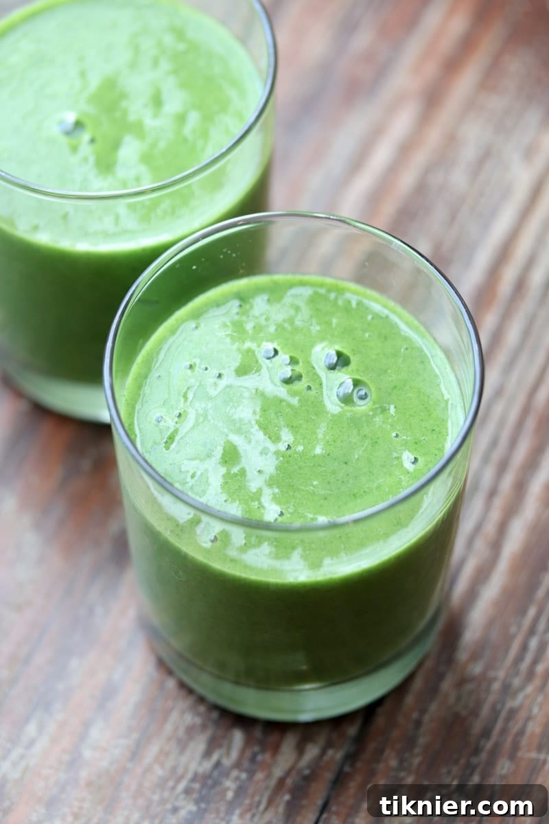 A perfectly balanced Mango Pineapple Kale Smoothie, showcasing its vibrant green color. A healthy, Whole30 and Paleo friendly drink that tastes amazing.