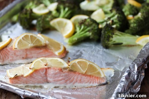 Close-up of flaky Lemon Dijon Sheet Pan Salmon with tender broccoli florets, showcasing a healthy and delicious meal.