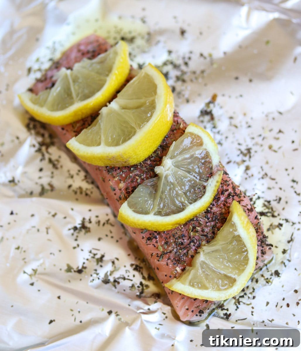 Fresh Atlantic salmon fillets seasoned with herbs and lemon, ready for roasting.