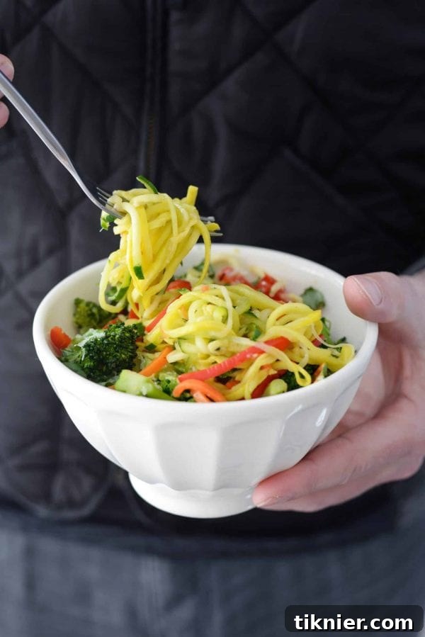 A fresh bowl of Zucchini Noodle Pasta Primavera bursting with colorful vegetables, a healthy and low-calorie dinner.