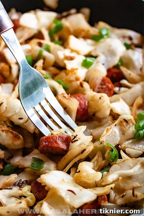 A savory Skillet Cabbage and Sausage dish, a quick and inexpensive dinner meal cooked in one pan.