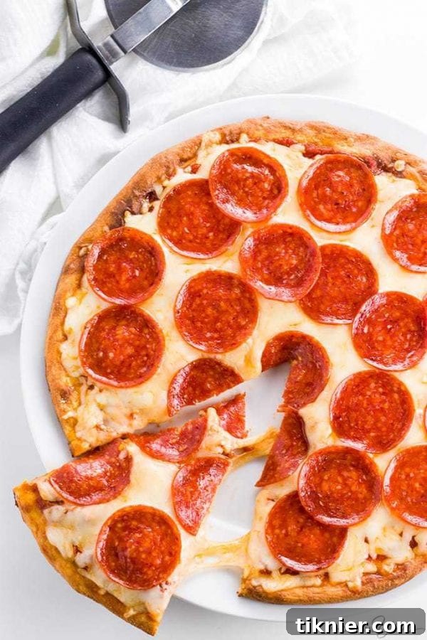 A delicious Keto Fathead Pizza Crust, topped with vibrant ingredients like tomatoes, basil, and cheese, ready for a low-carb dinner.