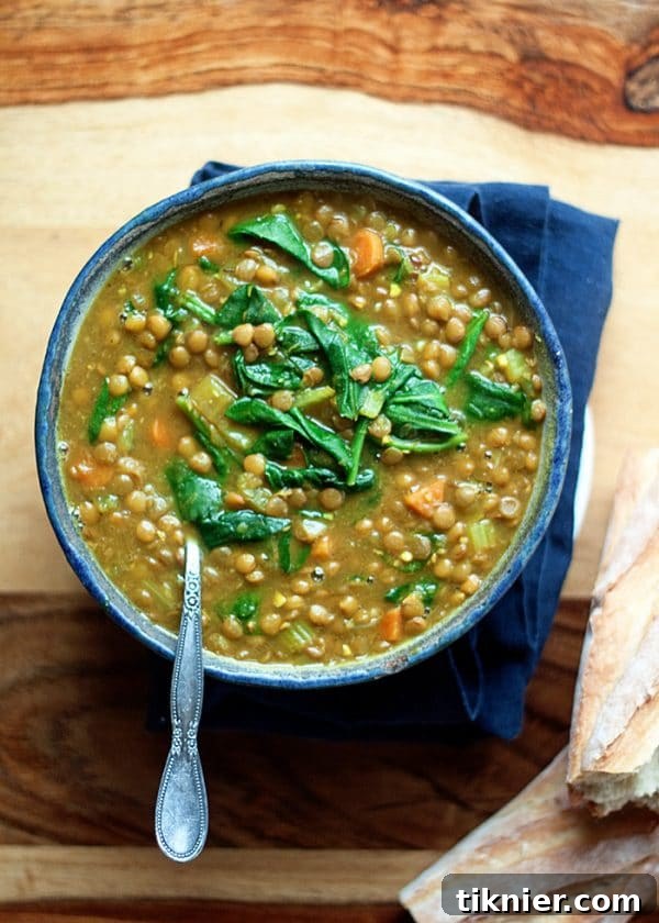 A bowl of vibrant Instant Pot Golden Lentil Spinach Soup, garnished with fresh cilantro, a healthy vegan and comforting meal.