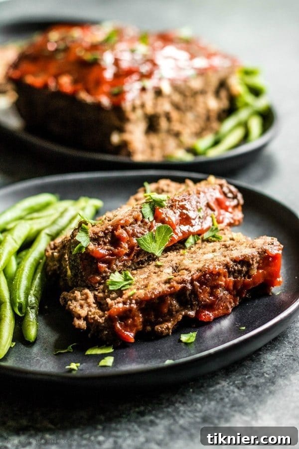 A slice of delicious Low Carb Meatloaf served with fresh herbs, offering a healthy and satisfying dinner option.