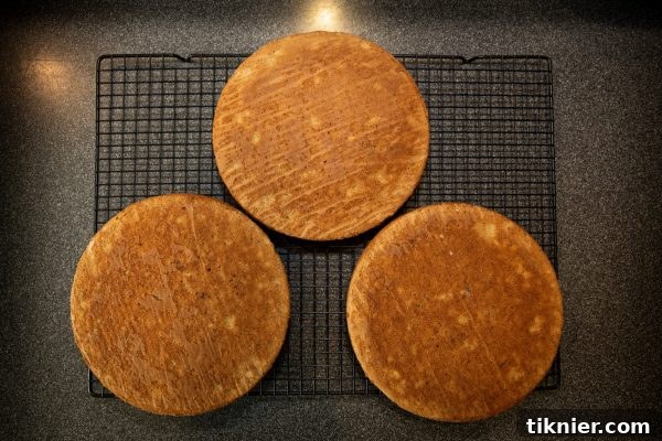 Warm cake layers cooling on wire racks.
