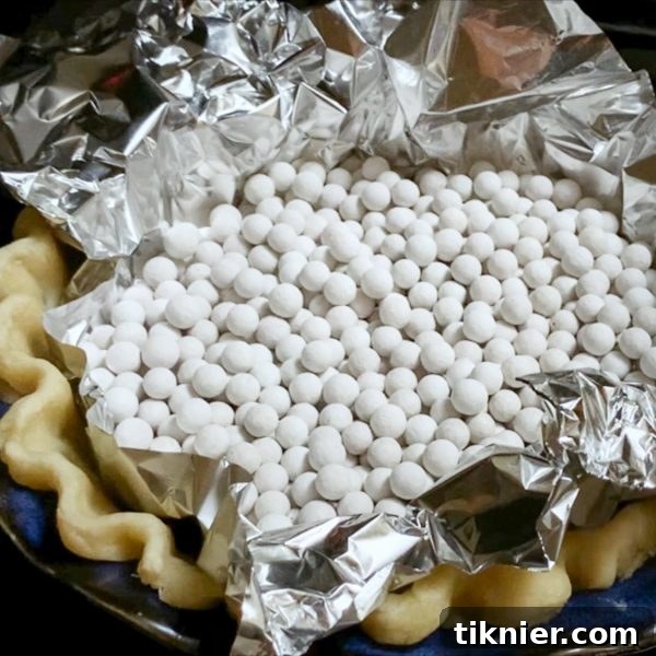 Irresistible Chess Pie 19 removing ceramic pie weights from a partially baked pie crust