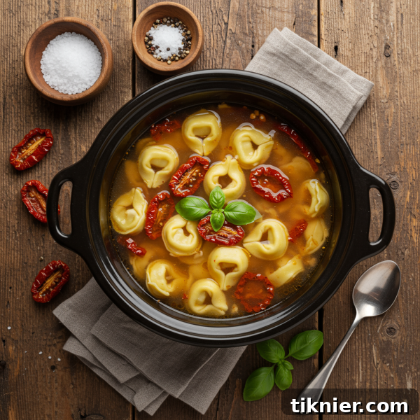 A bowl of slow cooker tortellini soup garnished with fresh basil and Parmesan cheese.