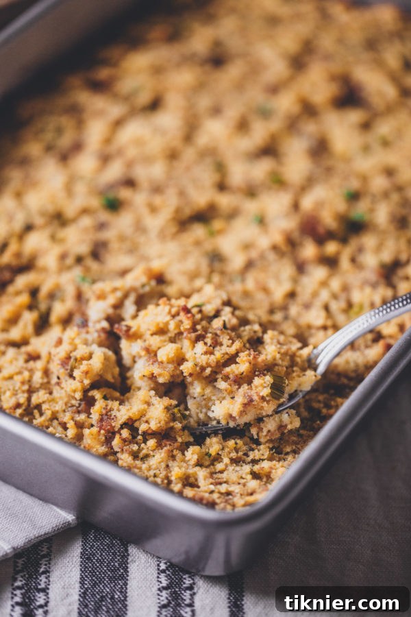 A white bowl filled with creamy turkey gravy, garnished with fresh herbs, ready to be poured over Thanksgiving dishes.