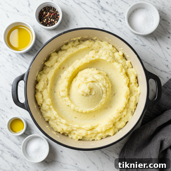 Effortless Velvety Mashed Potatoes 2 Lush, creamy mashed potatoes with a sprinkle of fresh chives, ready to be served in a rustic bowl.