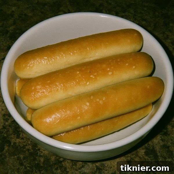 A basket of golden, warm, and buttery homemade Olive Garden breadsticks, fresh from the oven, ready to be served.