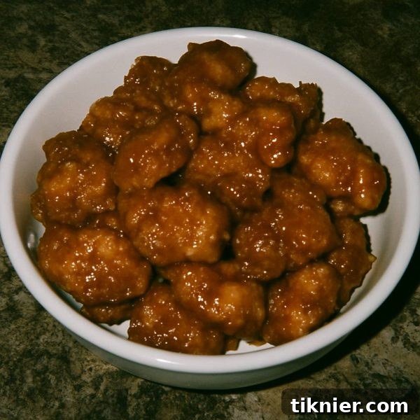 Delicious Homemade Panda Express Orange Chicken ready to be served, garnished with sesame seeds and green onions.