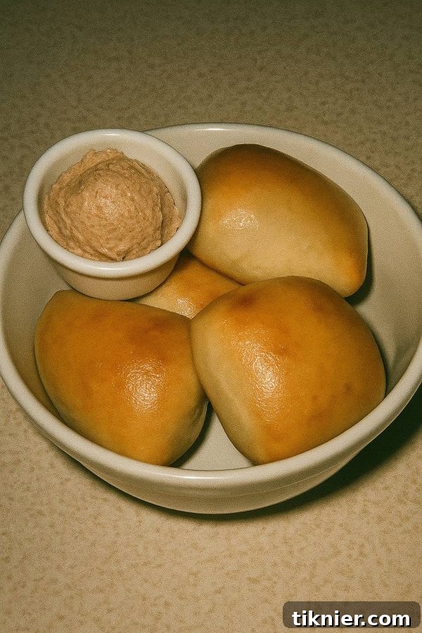 Warm, golden Texas Roadhouse Rolls with cinnamon butter spread