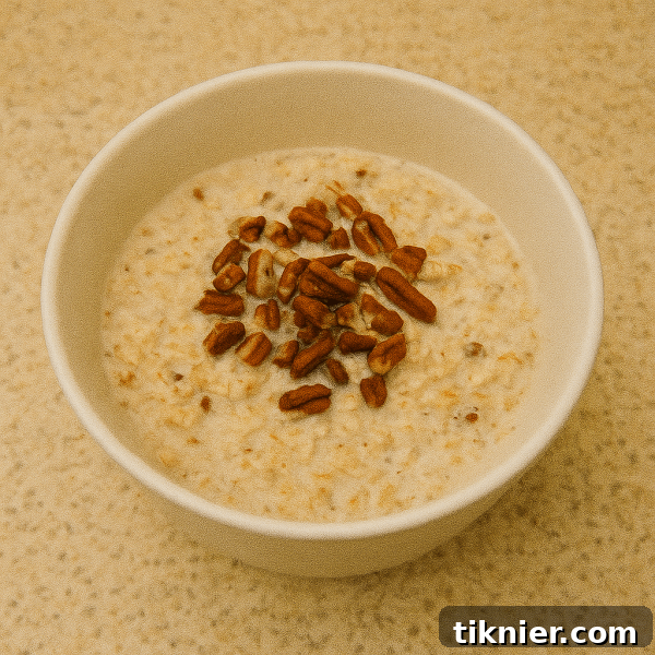 Delicious Brown Butter Pecan Overnight Oats in a mason jar, topped with pecans.