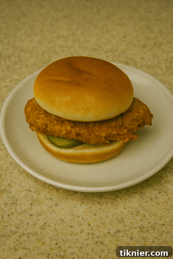 Delicious homemade fried chicken sandwich with spicy pickles on a brioche bun, mimicking a famous fast-food classic.