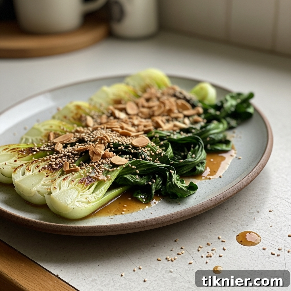 Close-up of golden brown butter miso sauce clinging to crisp-tender bok choy, with a garnish of almonds.