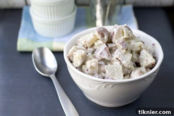 A serving of tangy red potato bacon salad, a refreshing cold side dish for Thanksgiving.