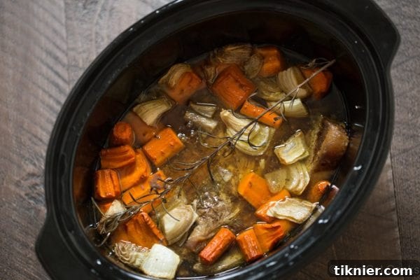 A mix of roasted root vegetables, including carrots and potatoes, showing caramelized edges.