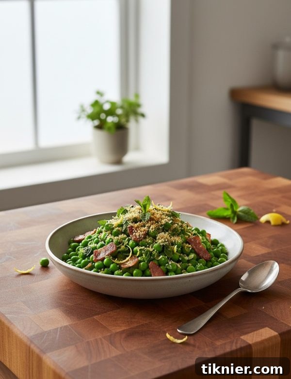 A close-up shot of Sweet Peas with Crispy Pancetta and Lemon-Mint Gremolata in a white serving bowl, garnished beautifully.